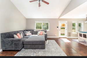 Living room featuring lofted ceiling, dark wood-type flooring, and ceiling fan