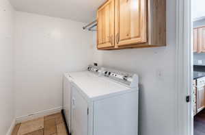 Washroom featuring cabinets and separate washer and dryer