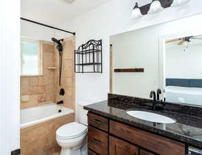 Full bathroom featuring ceiling fan, vanity, toilet, and tiled shower / bath combo