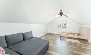 Bedroom featuring lofted ceiling, a textured ceiling, ceiling fan, and light wood-type flooring