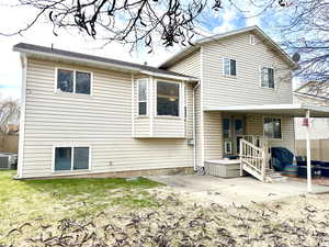 Rear view of house with cooling unit and a patio area