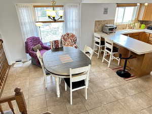 Tiled dining area with sink and a notable chandelier