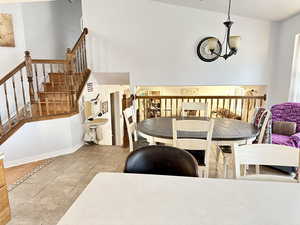 Dining area with light tile patterned floors and a chandelier