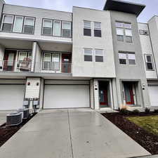 Townhome / multi-family property with a garage and central air condition unit