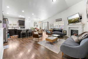 Living room with a fireplace, lofted ceiling, dark hardwood / wood-style floors, and sink