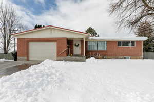 Ranch-style house with brick siding, driveway, and an attached garage