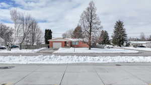 Snowy yard featuring a garage and driveway