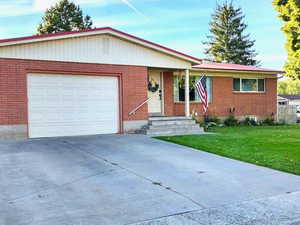 Single story home featuring a garage and a front yard