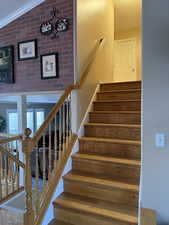 Stairway with ornamental molding and lofted ceiling