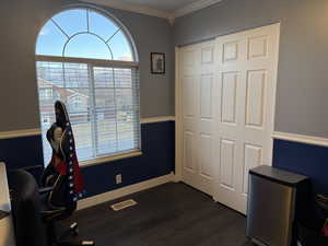 Office space with ornamental molding and dark hardwood / wood-style floors