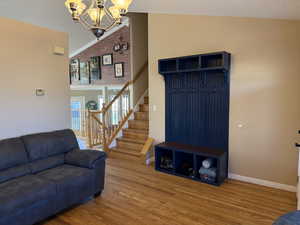 Interior space with lofted ceiling, a chandelier, and hardwood / hardwood floors