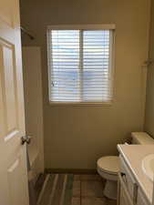 Bathroom featuring tile patterned flooring, vanity, and toilet