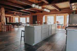 Kitchen with wood ceiling, stone tile floors, beamed ceiling, and pool table