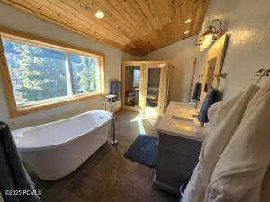 Sauna/Steam room /Bathroom with vanity, vaulted ceiling, wooden ceiling, and a tub to relax in