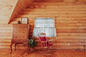 Sitting room with rustic walls and light wood-type flooring
