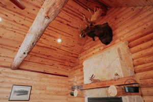 Details featuring log walls, visible vents, beamed ceiling, and wooden ceiling