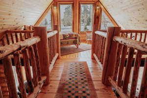 Additional living space with light wood-style flooring, wood ceiling, and lofted ceiling