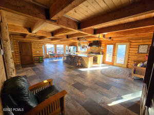 Living room featuring beamed ceiling, wood ceiling, and french doors