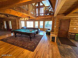 Playroom with hardwood / wood-style flooring, beam ceiling, and high vaulted ceiling