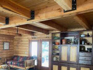 Interior space with wood ceiling, beam ceiling, french doors, and log walls