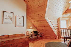 Sitting room with light wood finished floors, wooden ceiling, and lofted ceiling