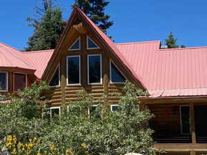 Rear view of property with a metal roof, log exterior, and a porch