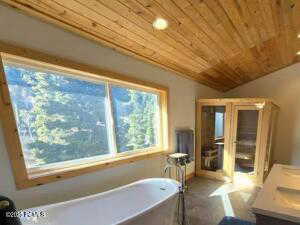 Sauna Steam room/Bathroom with lofted ceiling, a bathtub, vanity, and wooden ceiling