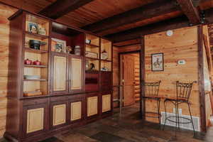Unfurnished room featuring wooden walls, wooden ceiling, and beam ceiling