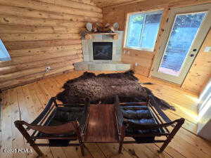 Living room with wood-type flooring and log walls