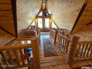 Interior space featuring ceiling fan, wood-type flooring, and vaulted ceiling