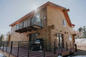 View of home's exterior with log exterior and a balcony