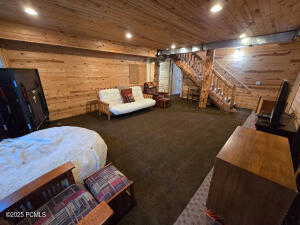 Bedroom featuring wooden walls and wooden ceiling