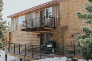 Back of property featuring metal roof and a balcony