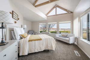 Bedroom with lofted ceiling with beams and carpet