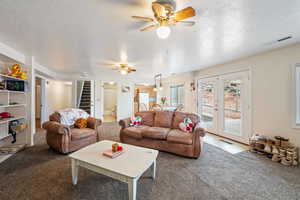 Living room with carpet floors, french doors leading to the deck, and a textured ceiling