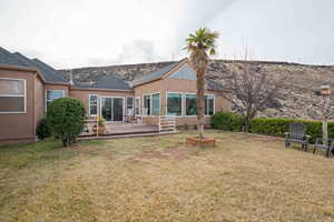 Rear view of property with a yard and a deck