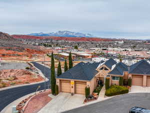 View of front of home with an attached garage, a mountain view, central air condition unit, driveway, and stucco siding