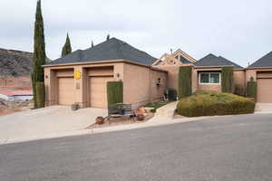 View of front of house with central AC and a garage