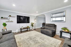 Living room featuring ornamental molding, hardwood / wood-style floors, and a textured ceiling