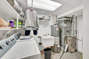 Washroom featuring separate washer and dryer, sink, and gas water heater