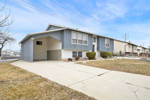 View of front facade featuring a front yard and a carport