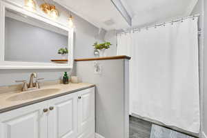 Bathroom with vanity, hardwood / wood-style floors, and a textured ceiling