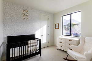 Carpeted bedroom with a mountain view and a nursery area