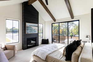 Carpeted bedroom featuring beamed ceiling, high vaulted ceiling, access to exterior, and a fireplace