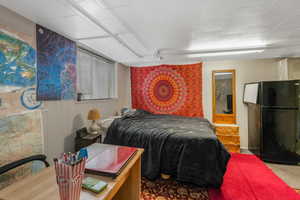 Bedroom with black fridge