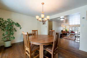 Dining area with a chandelier and dark hardwood / wood-style flooring