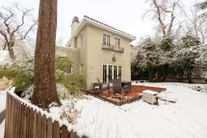 Snow covered back of property featuring a balcony