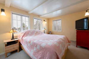 Bedroom with beamed ceiling and carpet