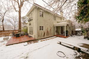 Snow covered house with central AC and a patio area