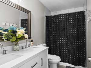 Master bathroom with vanity, toilet, a textured ceiling, and shower